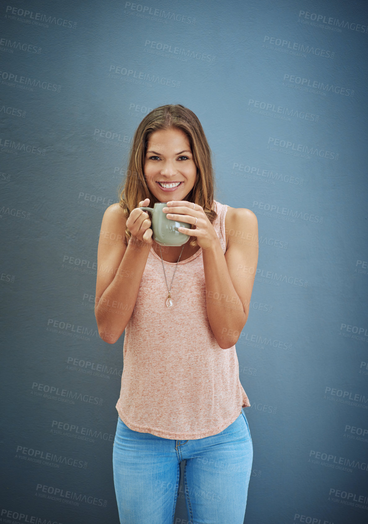 Buy stock photo Studio portrait of a young woman drinking a beverage against a gray background