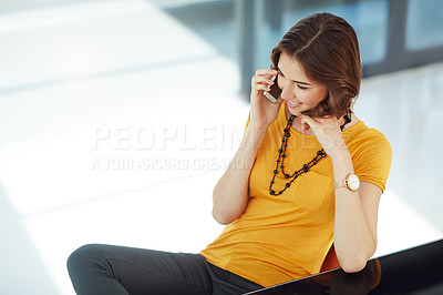 Buy stock photo Cropped shot of a young businesswoman talking on her cellphone while sitting in the office