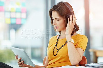 Buy stock photo Cropped shot of a young businesswoman watching something on her tablet while sitting in the office