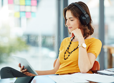 Buy stock photo Cropped shot of a young businesswoman watching something on her tablet while sitting in the office