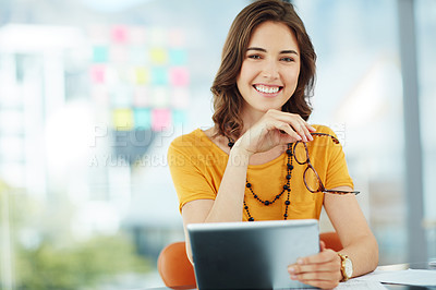 Buy stock photo Cropped portrait of a young businesswoman working on her tablet in the office