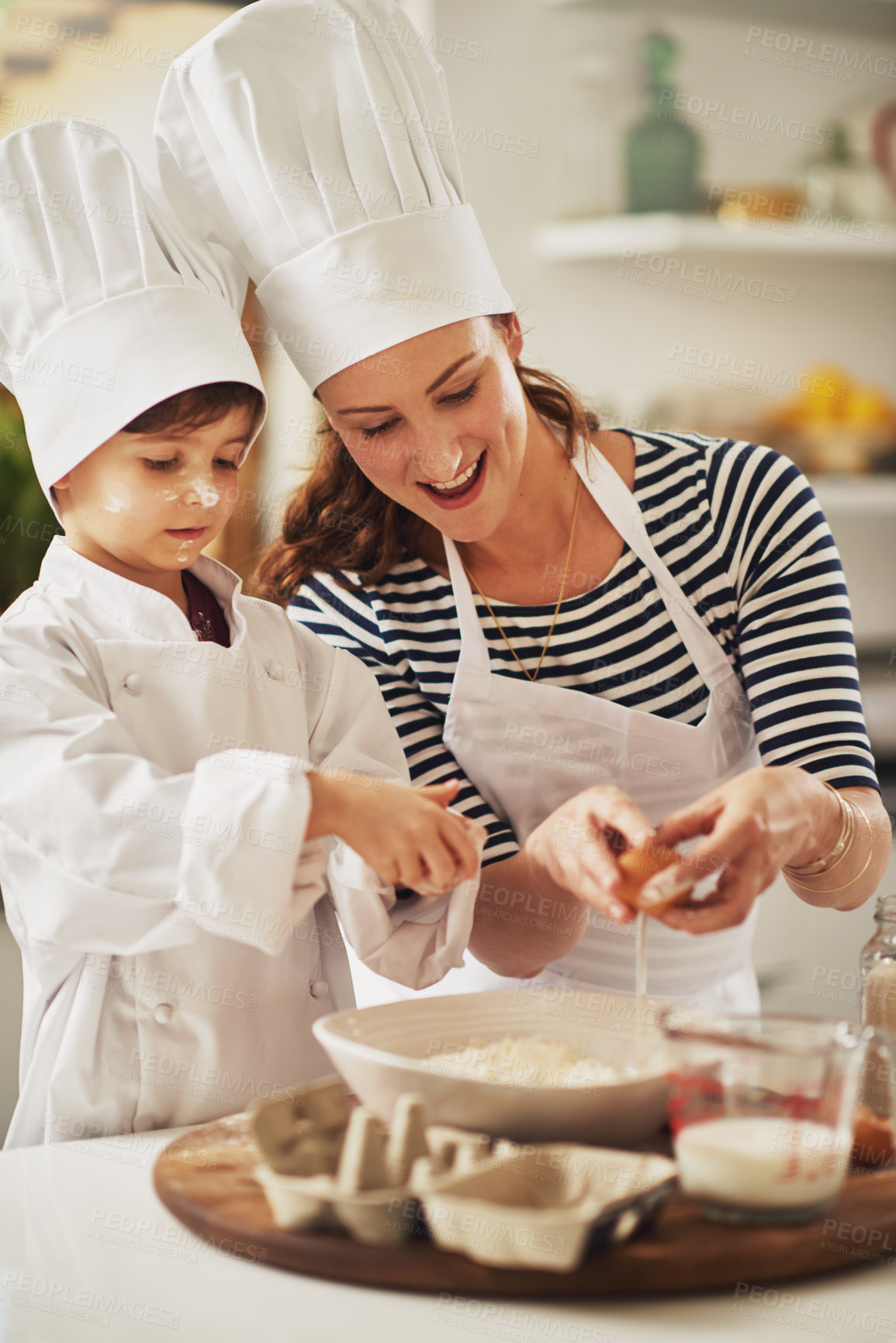 Buy stock photo Shot of a mother and her young son baking together in the kitchen