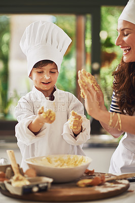 Buy stock photo Shot of a mother and her young son with dough on their hands baking together in the kitchen