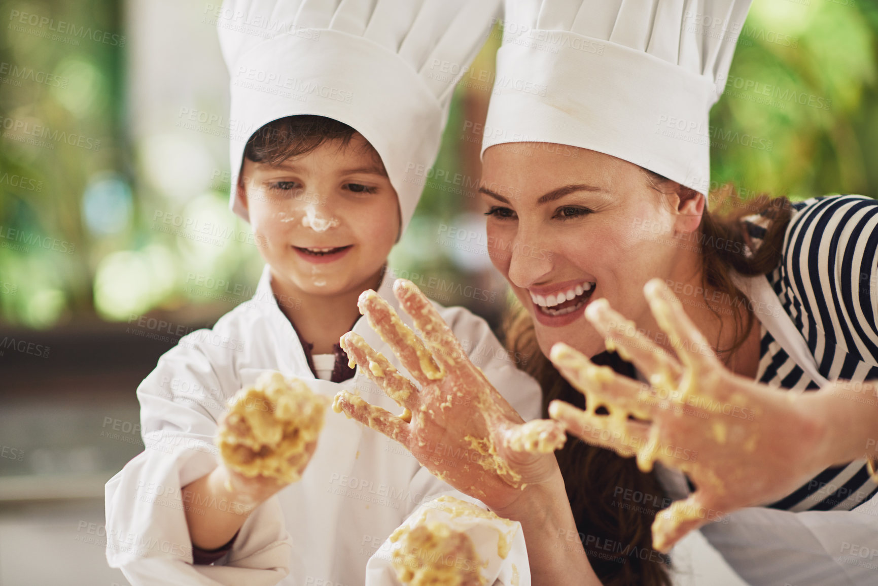 Buy stock photo Shot of a mother and her young son with dough on their hands baking together in the kitchen