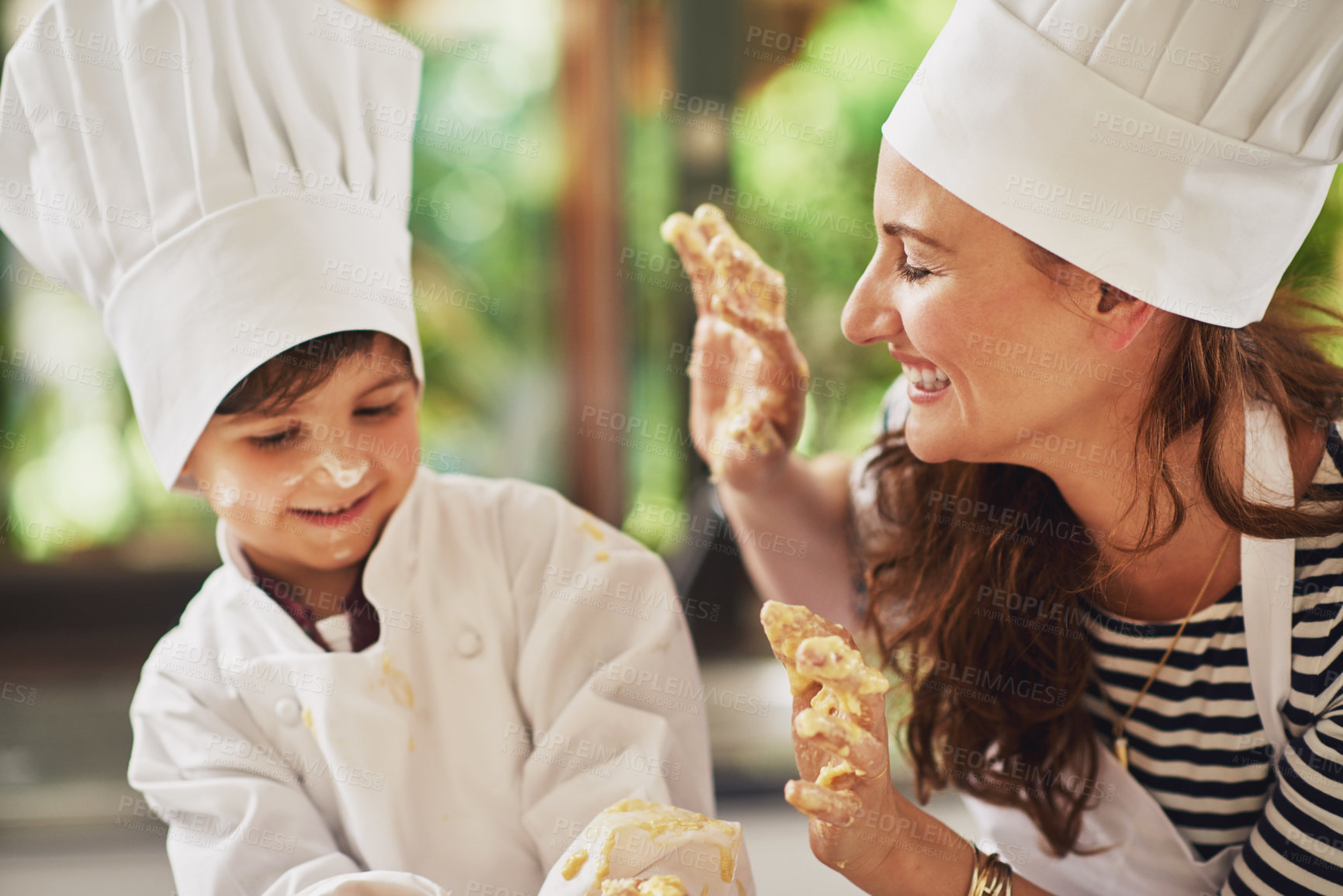 Buy stock photo Baking, playing and child with mom cooking, learning and support with parent with chef costume and smile. Happy, family kitchen and food with messy hands for dessert with dough in home with love