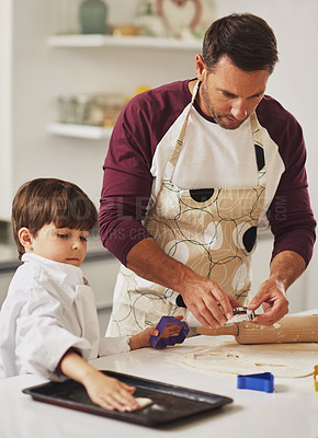 Buy stock photo Shot of a father and his young son baking cookies together in the kitchen
