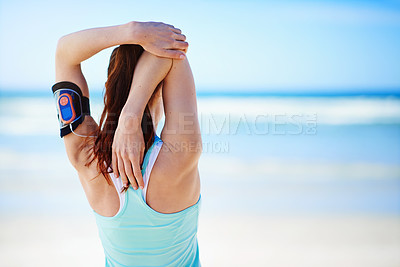 Buy stock photo Rearview shot of a young woman stretching before a work out on the beach