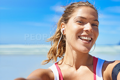 Buy stock photo Shot of a young woman taking a selfie while working out on the beach