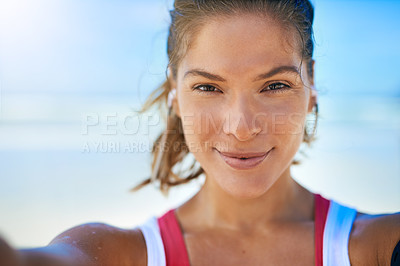 Buy stock photo Shot of a young woman taking a selfie while working out on the beach