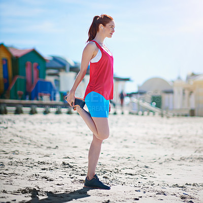 Buy stock photo Full length shot of a young woman stretching before a work out on the beach