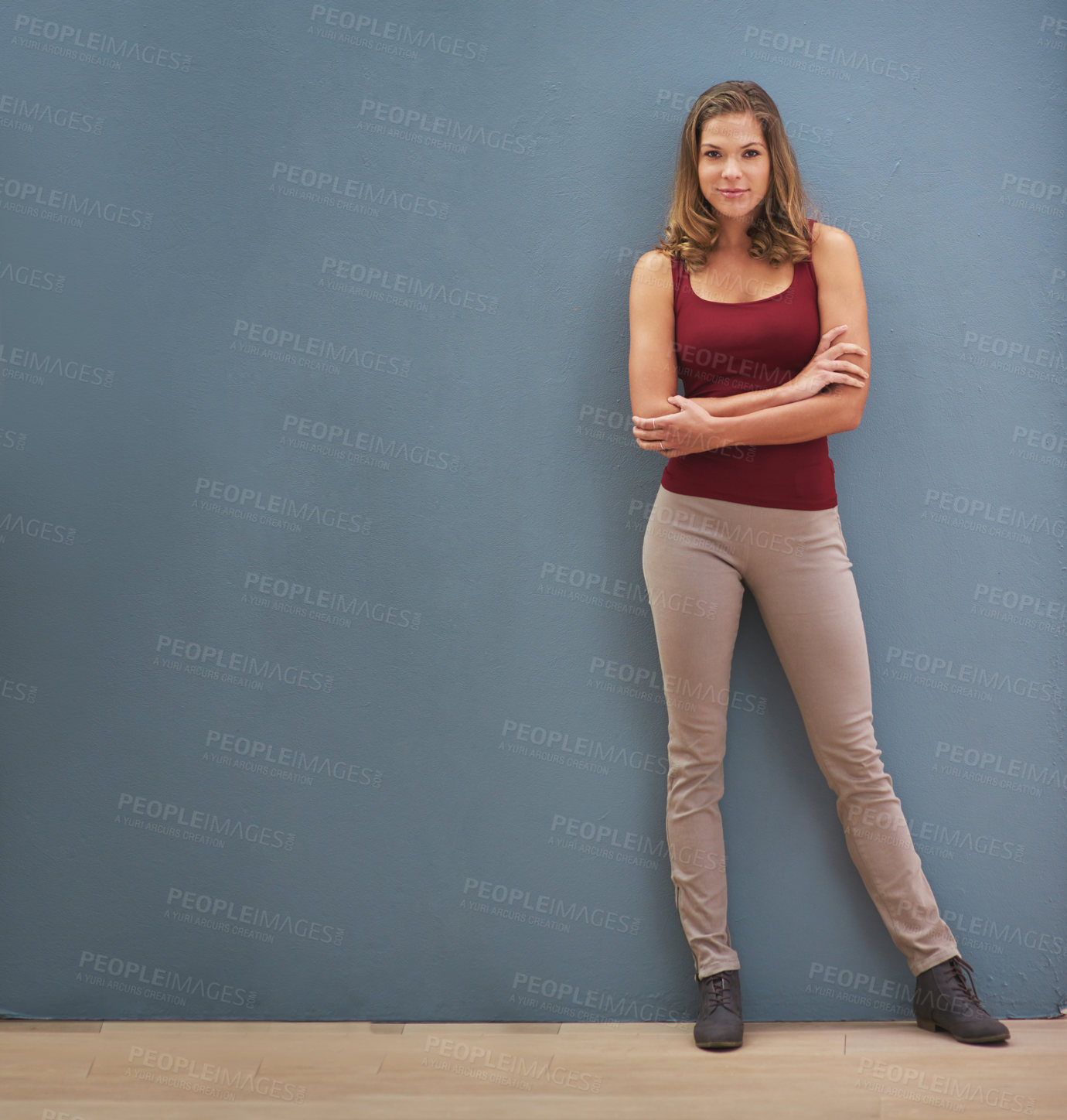 Buy stock photo Portrait of a smiling young woman posing against a gray wall