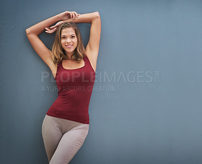 Buy stock photo Portrait of a smiling young woman posing against a gray background