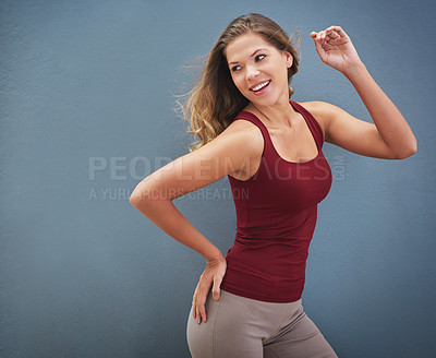 Buy stock photo Shot of a carefree young woman posing against a gray background
