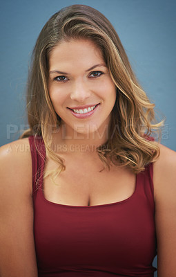 Buy stock photo Portrait of a smiling young woman posing against a gray background