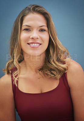 Buy stock photo Portrait of a smiling young woman posing against a gray background