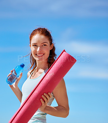 Buy stock photo Shot of a young woman posing with her yoga mat on the beach