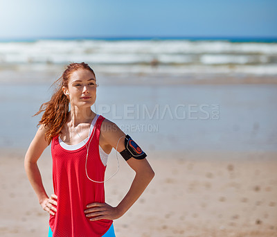 Buy stock photo Cropped shot of a young woman standing with her hands on her hips on the beach
