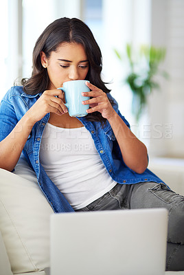 Buy stock photo Woman, laptop and relax on sofa with coffee for morning routine, working online or read social media communications on tech. Drink tea, peace on couch and streaming news or web blog on computer 