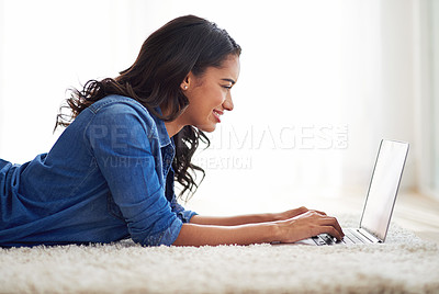 Buy stock photo Shot of a young woman browsing the web on her laptop at home