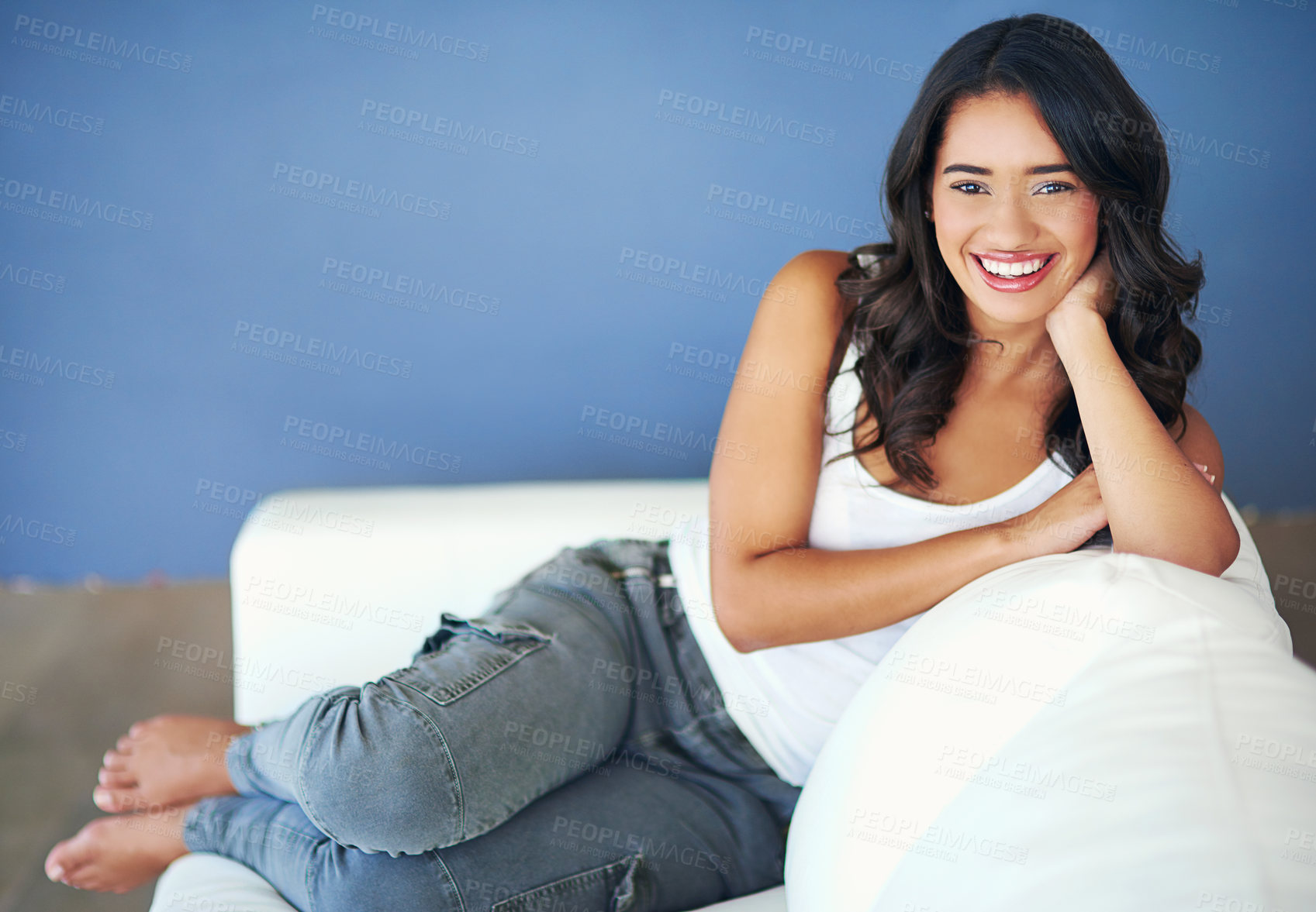 Buy stock photo Portrait of a young woman relaxing on the sofa at home