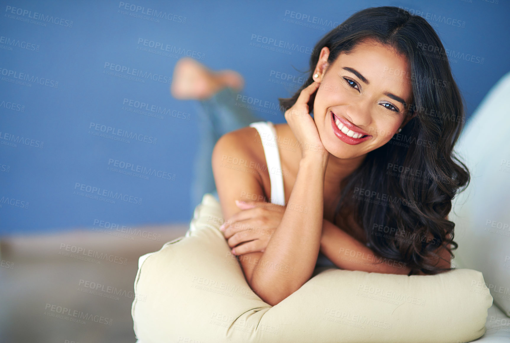 Buy stock photo Face, portrait and woman lying on sofa in living room of home alone. Happy, smile and young female from India relaxing on her comfortable couch in lounge, smiling and enjoying quality time in house.