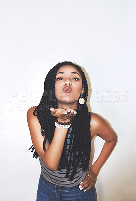 Buy stock photo Studio portrait of an attractive young woman blowing a kiss