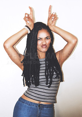 Buy stock photo Portrait, hand gesture and horns with a black woman posing in studio on a gray background for quirky fun. Face, fashion and beauty with an attractive young female making a devil horn sign with hands