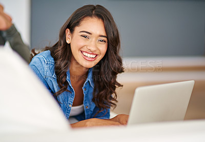 Buy stock photo Cropped portrait of an attractive young woman using her laptop while lying on the sofa