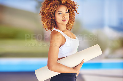 Buy stock photo Cropped shot of a sporty young woman holding her yoga mat