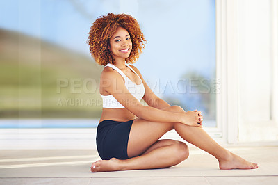 Buy stock photo Shot of a sporty young woman sitting on the floor
