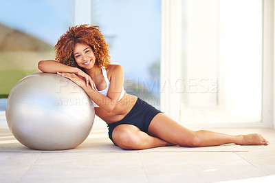 Buy stock photo Shot of a young woman leaning against her exercise ball