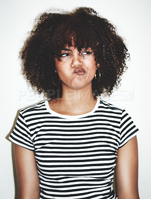 Buy stock photo Studio shot of a young woman pulling faces against a gray background