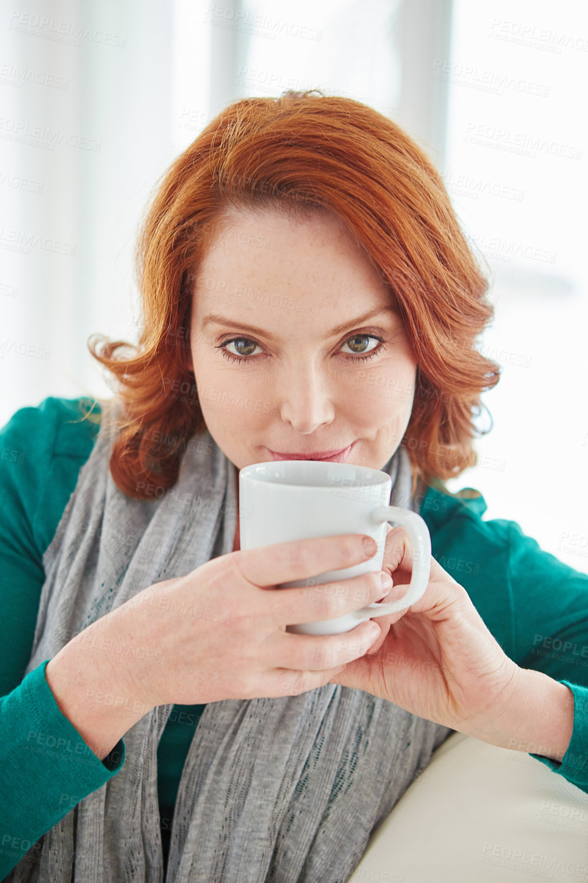 Buy stock photo Cropped portrait of a mature woman drinking coffee while relaxing on the sofa at home