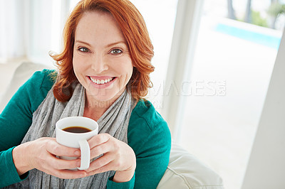 Buy stock photo Cropped portrait of a mature woman drinking coffee while relaxing on the sofa at home