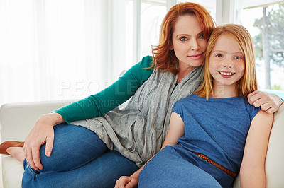Buy stock photo Shot of a mother and young daughter sitting on the sofa at home