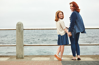 Buy stock photo Shot of a mature woman and her young daughter at the waterfront 