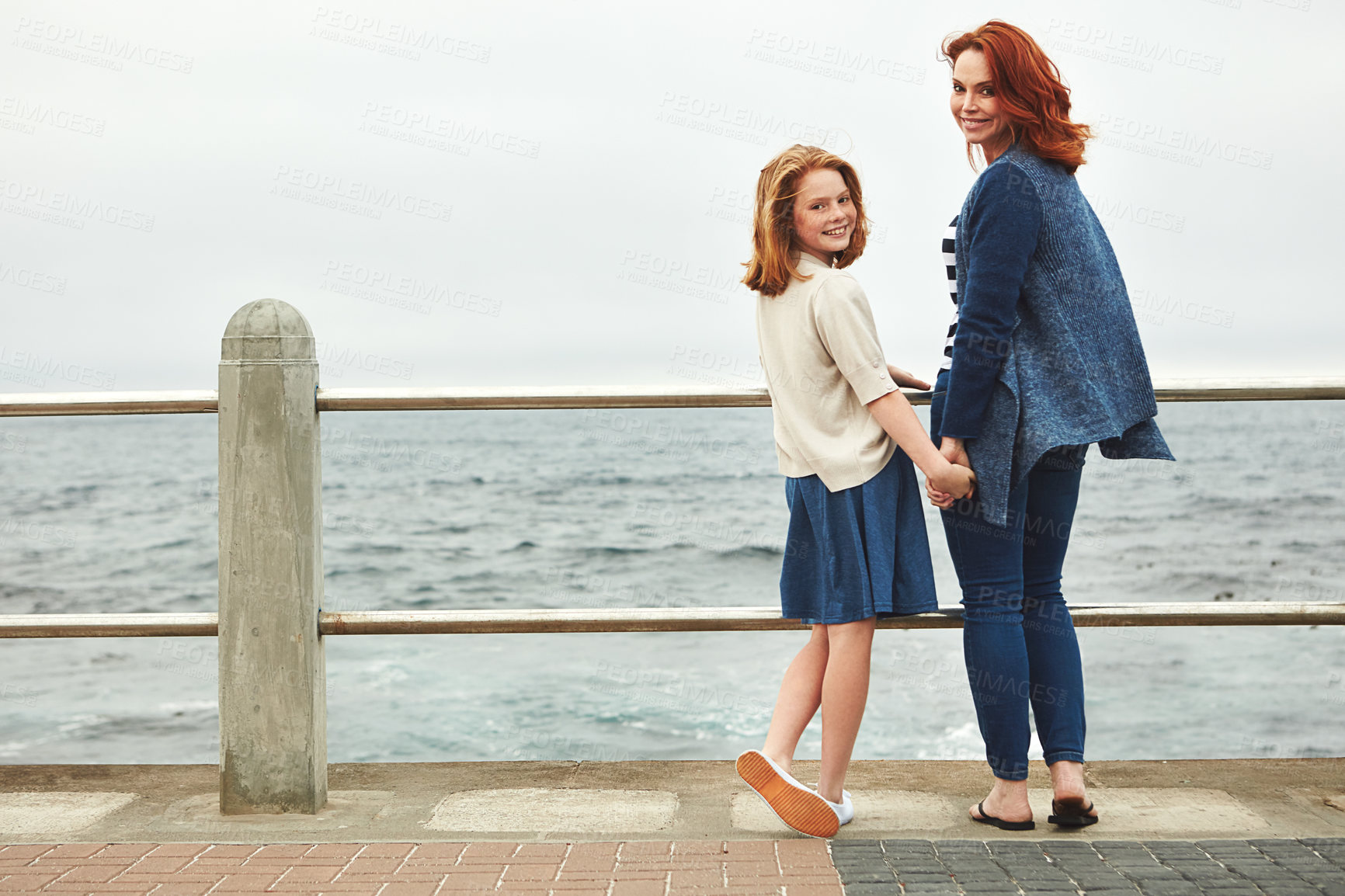 Buy stock photo Shot of a mature woman and her young daughter at the waterfront 