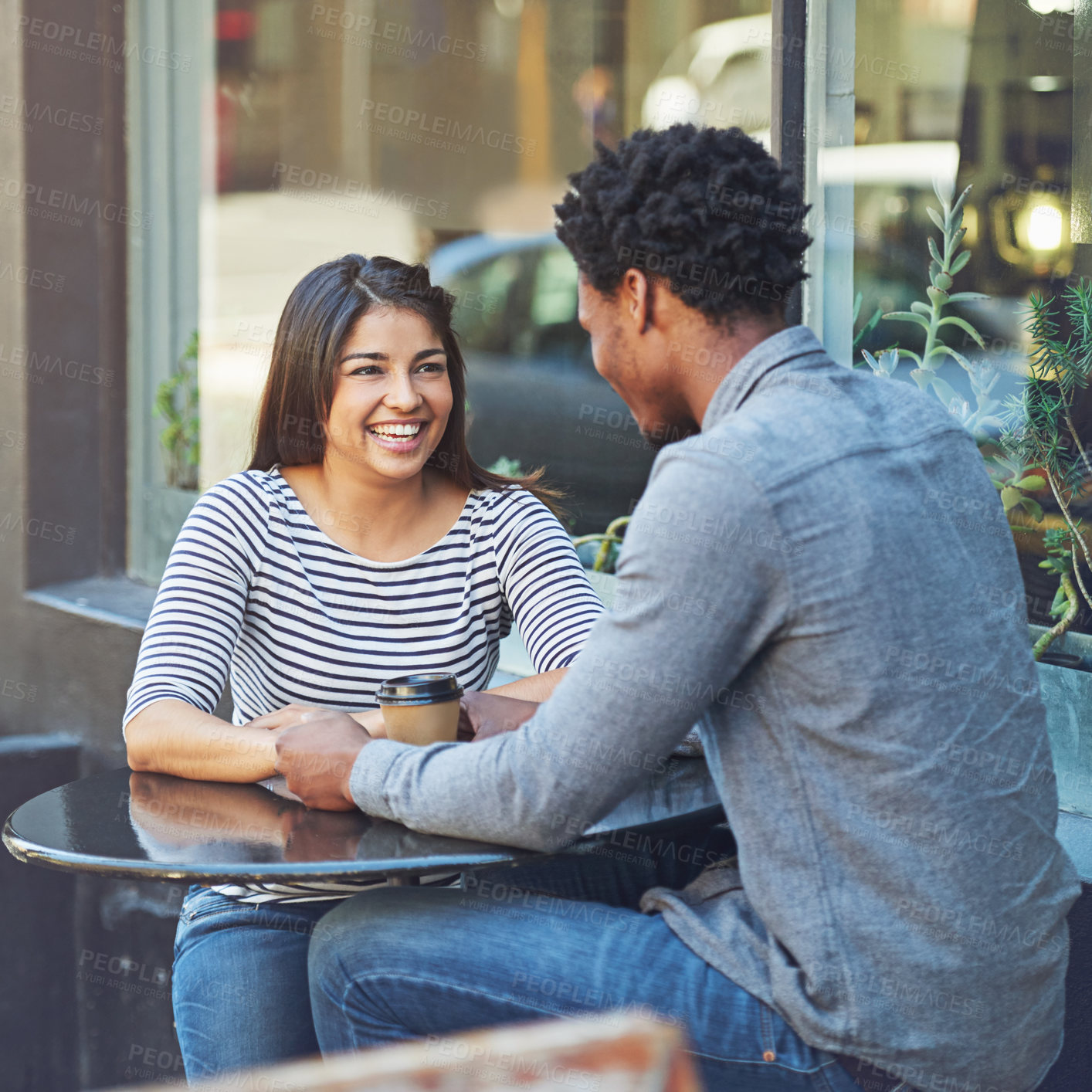 Buy stock photo Shot of a young couple on a coffee date at a sidewalk cafe