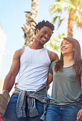 Buy stock photo Shot of a happy young couple going for a walk through the city