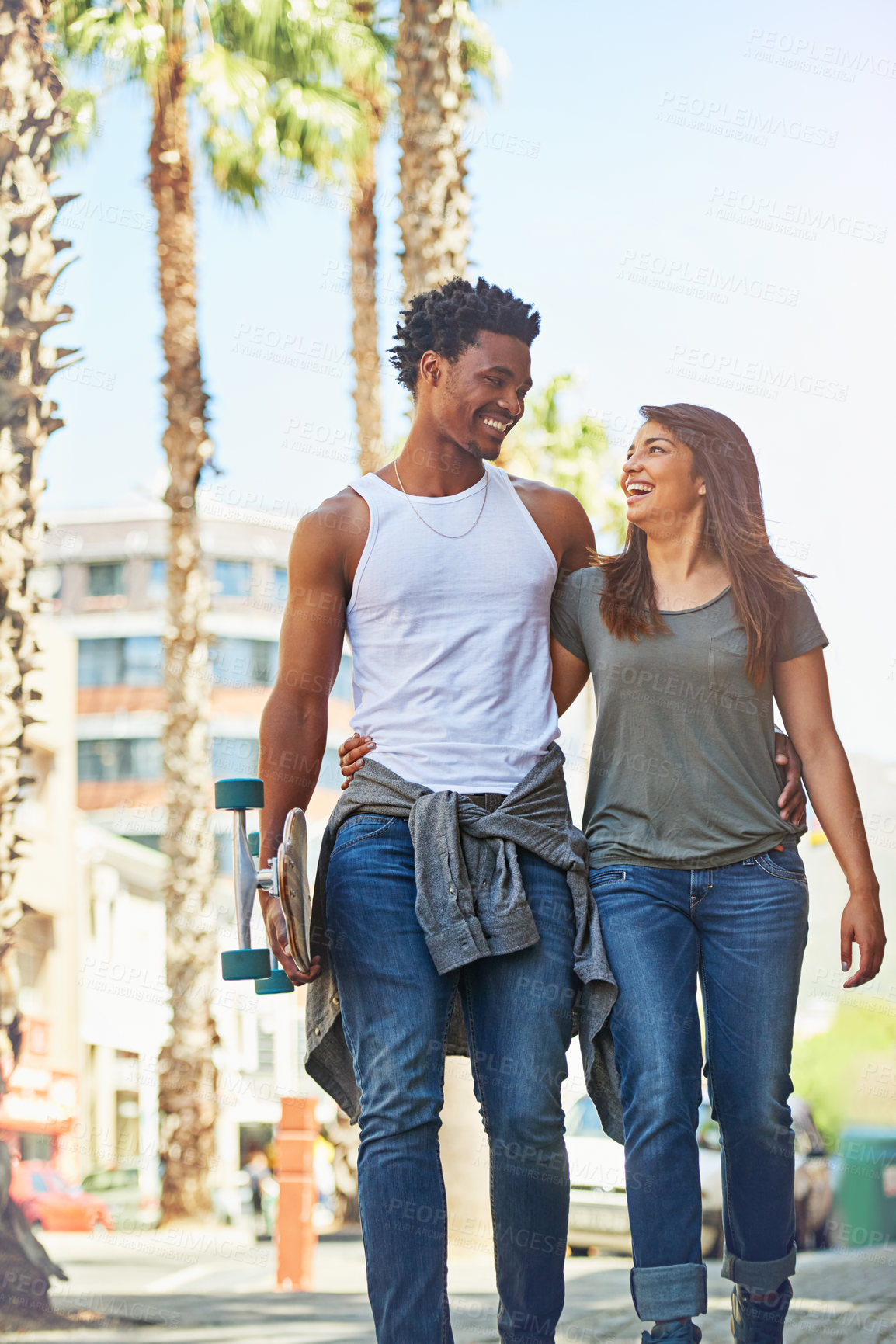 Buy stock photo Shot of a happy young couple going for a walk through the city