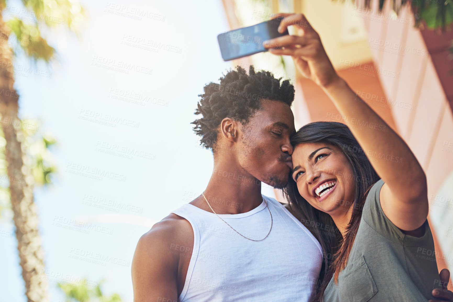 Buy stock photo Selfie, kiss and interracial couple with phone in the city, date and happiness with memory together. 5g technology, love and black man and woman with affection for a mobile photo with a smile