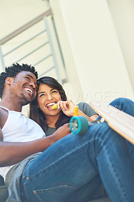 Buy stock photo Shot of a happy young couple eating ice lollies together