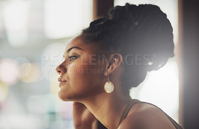 Buy stock photo Cropped shot of an attractive young woman sitting in a coffee shop