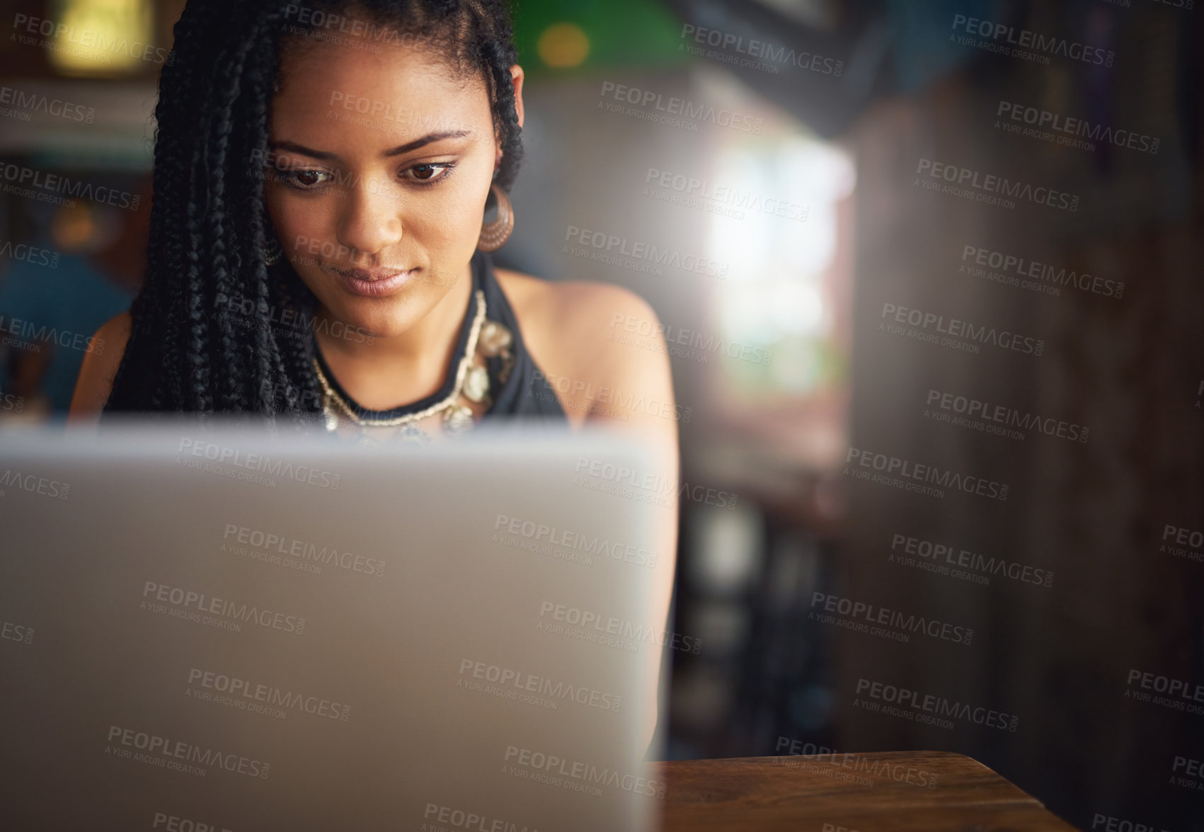 Buy stock photo Cropped shot of an attractive young woman using her laptop in a coffee shop