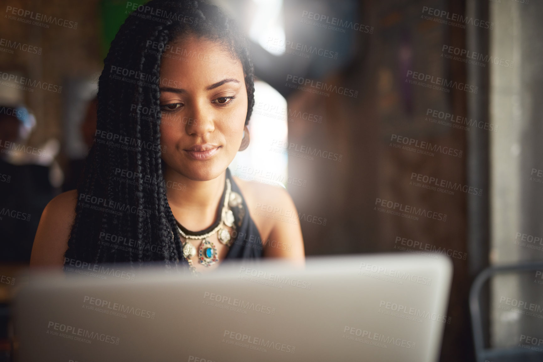 Buy stock photo Cropped shot of an attractive young woman using her laptop in a coffee shop