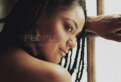 Buy stock photo Cropped shot of an attractive young woman sitting by the window