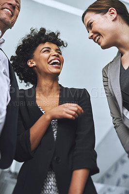 Buy stock photo Shot of colleagues laughing together in an office