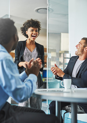 Buy stock photo Shot of colleagues laughing together in an office