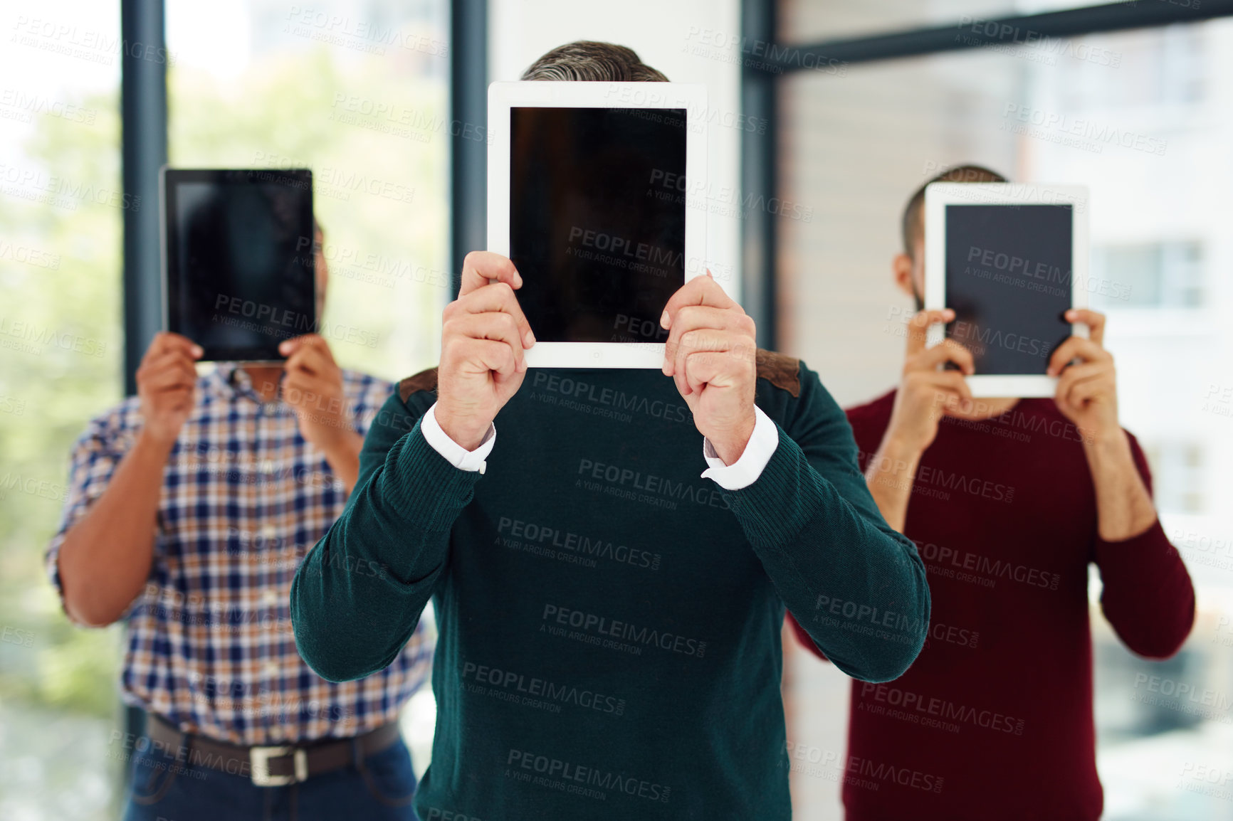 Buy stock photo Cropped shot of a group of businesspeople standing with their tablets over their faces