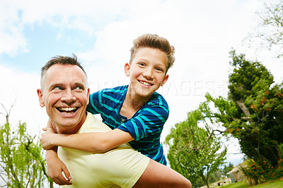 Buy stock photo Shot of a dad giving his son a piggyback outside